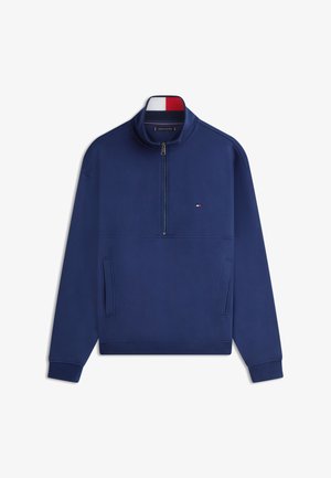 Tengerészkék pulóverfelső félcipzáras gallérral, bordázott szegéllyel és mandzsettával, két oldalzsebbel és egy kis logóval a mellrészen.