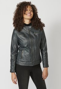 Giacca da moto in pelle nera con un design strutturato, dotata di quattro tasche con zip, colletto a scatto e dettagli trapuntati lungo le maniche.