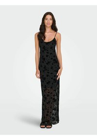 Svart maxikjole med blomstret blondermønster, spaghettistropper og gjennomsiktig nedre del. Glatt tekstur med en tettsittende overdel og flytende silhuett.