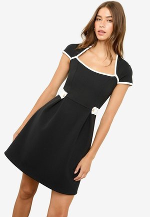 Black dress with short sleeves, square neckline, white accents, and decorative buttons near the waist. Smooth texture and fitted design.