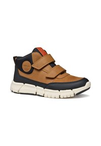 Zapato alto de cuero marrón y sintético negro con dos correas de velcro, suela de goma texturizada y un acento rojo cerca de la lengüeta.