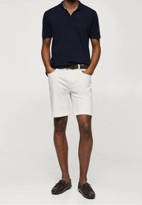 Navy-poolopaita, valkoiset puuvillahousut, ruskea vyö, ruskeat loafersit. Klassinen istuvuus, lyhyet hihat, siistit linjat ja yksinkertainen muotoilu.