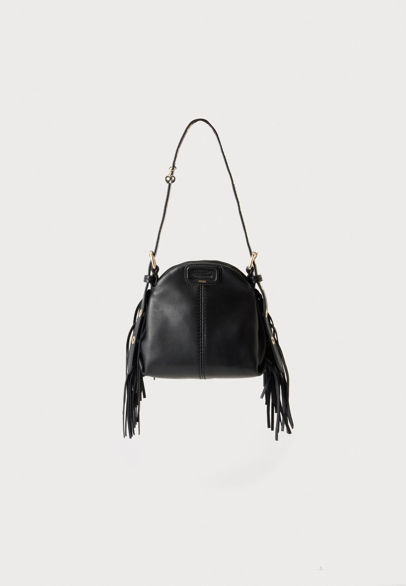 Sac à main en cuir noir avec une forme courbée, une longue bandoulière réglable et des franges de chaque côté sur un fond clair.