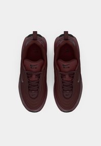 Bordo Nike Air sportbačiai su tekstūruotu viršumi, apvaliu pirštu, juodais akcentais ir logotipo detalizavimu ant liežuvėlio.