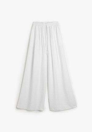 Weiße, weit geschnittene Hosen mit elastischem Bund und Kordelzug. Aus weichem Stoff gefertigt, mit glatter Textur und ohne sichtbare Muster.