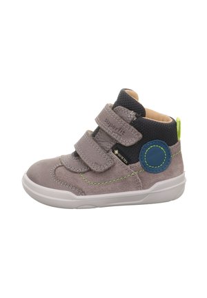 Graue Wildleder-Ankle Boots mit zwei Velcro-Riemen, einem strukturierten schwarzen Mesh-Kragen, einer weißen Gummisohle und grünen Nähten.