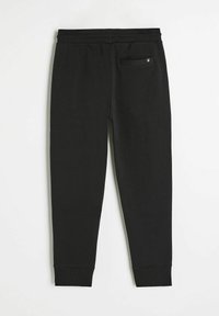 Czarne dresy wykonane z miękkiego materiału, z dopasowanym krojem, elastycznym paskiem w talii oraz małą tylną kieszenią z metką.