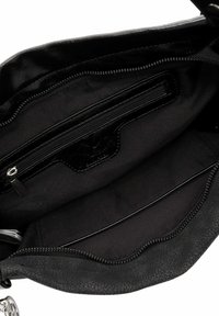 Melna ādas rokassomu iekšpuse ar rāvējslēdzēja un brīvu kabatu, redzama teksturēta odere un sudraba rāvējslēdzēja vilcējs.