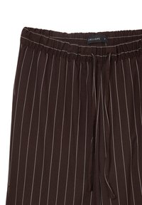 Pantalons rayés bruns en tissu doux, dotés d'une taille élastique avec un cordon de serrage et de fines rayures blanches pour plus de détail.