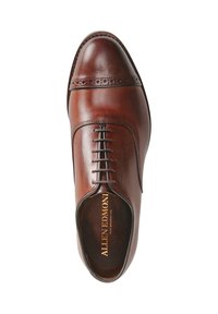 Chaussure habillée en cuir marron avec un bout rond, des coutures détaillées et un laçage à cinq œillets. Texture lisse avec une finition brillante.