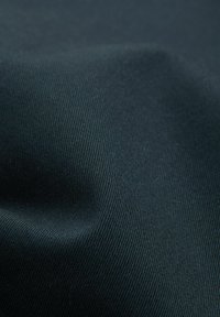 Dunkelgrüner Stoff mit glatter Textur und feinem Rippmuster, das einen sanften Glanz und subtile Farbvariationen zeigt.