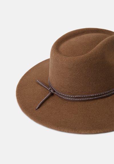 Chapeau en feutre marron avec un large bord, une couronne haute, et un ruban décoratif marron foncé autour de la base, ornée de coutures blanches et d'un détail en forme de nœud.