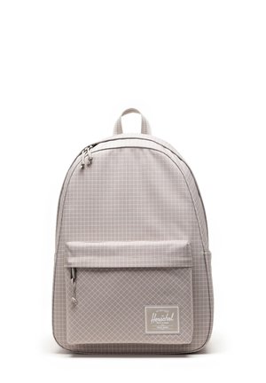 Sac à dos gris clair avec un motif de grille texturé, un dessus courbé, une poche à fermeture éclair à l'avant et une étiquette logo en tissu sur le panneau avant inférieur.