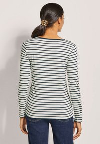 Langärmliges gestreiftes Oberteil in Creme und Marineblau, mit Rundhalsausschnitt und weicher Stoffqualität sowie einer taillierten Silhouette.