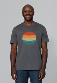 Graues T-Shirt mit einem kreisförmigen Design und horizontalen Streifen in Orange, Gelb, Grün und Blau. Kurze Ärmel und Rundhalsausschnitt.