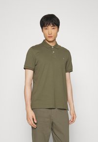 Oliven grøn polo-shirt lavet af bomuld. Korte ærmer, tre-knap lukning og lille logo på venstre bryst. Bæret med matchende bukser.