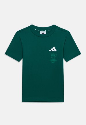 Tmavozelené tričko s krátkym rukávom s logom Adidas a malou grafikou Minecraft na ľavej strane hrudníka.