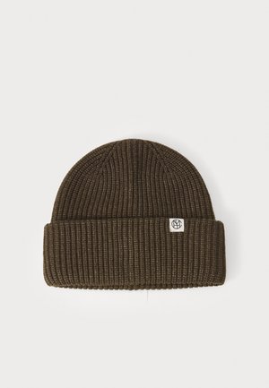 Knitted beanie in dark olive green, featuring a ribbed texture and a folded cuff. Small logo patch on the front. Round shape.