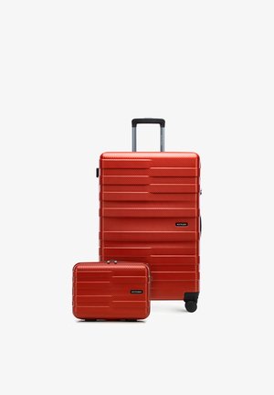 Red hard-shell suitcase with retractable handle and small matching carry-on bag, both with horizontal textured lines and black wheels.