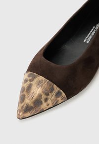 Chaussure en daim marron avec un bout pointu ; l'avant présente un motif léopard métallisé. L'intérieur est noir. Texture lisse dans l'ensemble.