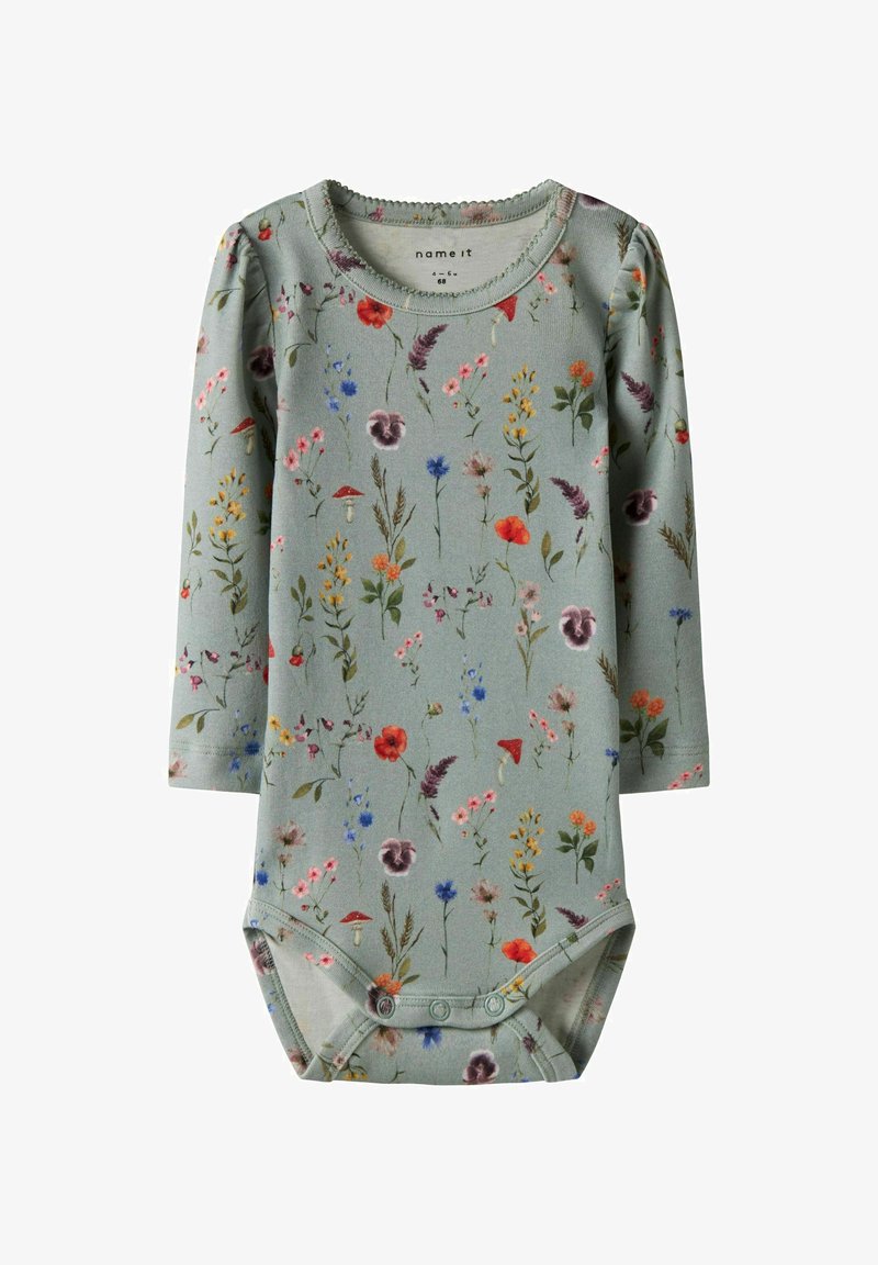 Langarm babyromper van lichtgroene katoen met een bloemenpatroon met rode, blauwe en gele bloemen. Drukknopen aan de onderkant.