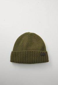 Õlivarjundis ribakudumist beanie, millel on volditud serv ja väike must ristkülikuline logootag, seismas täiesti valgel taustal.