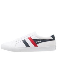 Sneaker bianca in tela con strisce diagonali blu e rosse, suola in gomma e accentuazione del marchio in bianco. Design con lacci, profilo basso.