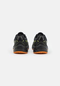 Scarpe da corsa nere con tomaia in rete, dettagli argentati riflettenti e suola in gomma arancione brillante. Tallone rinforzato e collo imbottito per supporto.