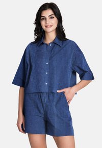 Blå, texturerad kortärmad skjorta med krage och knäppning, i kombination med matchande shorts, i en avslappnad passform.