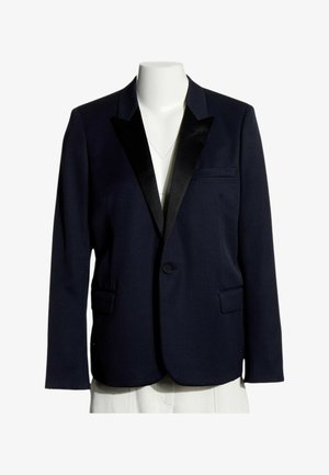 Blazer blu navy scuro a un bottone con revers in raso nero, tasche con patta e taschino sul petto su un manichino bianco senza testa.
