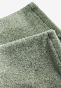 Groen fleece-stof, zachte textuur, opgevouwen met zichtbare stiksels langs de randen, lichtgewicht en warm, met een subtiel, uniform oppervlakpatroon.