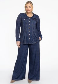 Denim shirt en wijde broek set in donkerblauw, met gouden knopen, dubbele borstzakken en contrasterende stiksels.