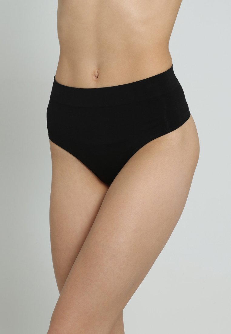 Culottes noires en coton taille haute avec une texture lisse, un design sans couture et sans matériel visible. Le tissu offre élasticité et confort.