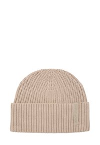 Beige gebreide muts met geribbelde textuur, omgeslagen rand en een klein stoffen label aan de zijkant, die een eenvoudige, functionele stijl uitstraalt.