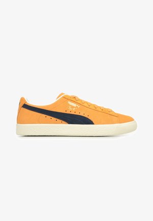 Sneakers in suede arancione con una striscia blu navy, dotati di una suola di gomma bianca testurizzata, lacci rotondi e logo Puma dorato di lato.