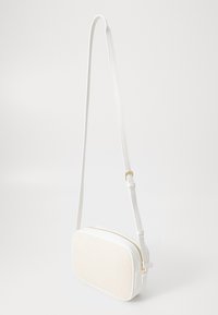 Biała torba na ramię z teksturowanym przednim panelem, złotymi elementami, regulowanym paskiem i prostokątnym kształtem. Gładki materiał syntetyczny.