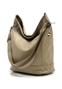 Sac à épaule en cuir beige avec un design décontracté et une bandoulière unique. Il présente un petit charme en forme de drapeau italien sur la tirette de la fermeture éclair. Texture lisse.
