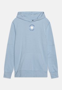 Sudadera azul clara hecha de tejido suave, con un bolsillo frontal, puños acanalados y un logotipo circular con una estrella en el pecho.