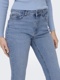 High-waisted blue denim jeans with a slim fit, featuring five pockets, belt loops, and a textured fabric finish.