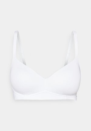 Soutien-gorge blanc sans couture avec bretelles ajustables, bonnets moulés et un design simple. Le tissu est lisse sans matériel visible ni motifs.