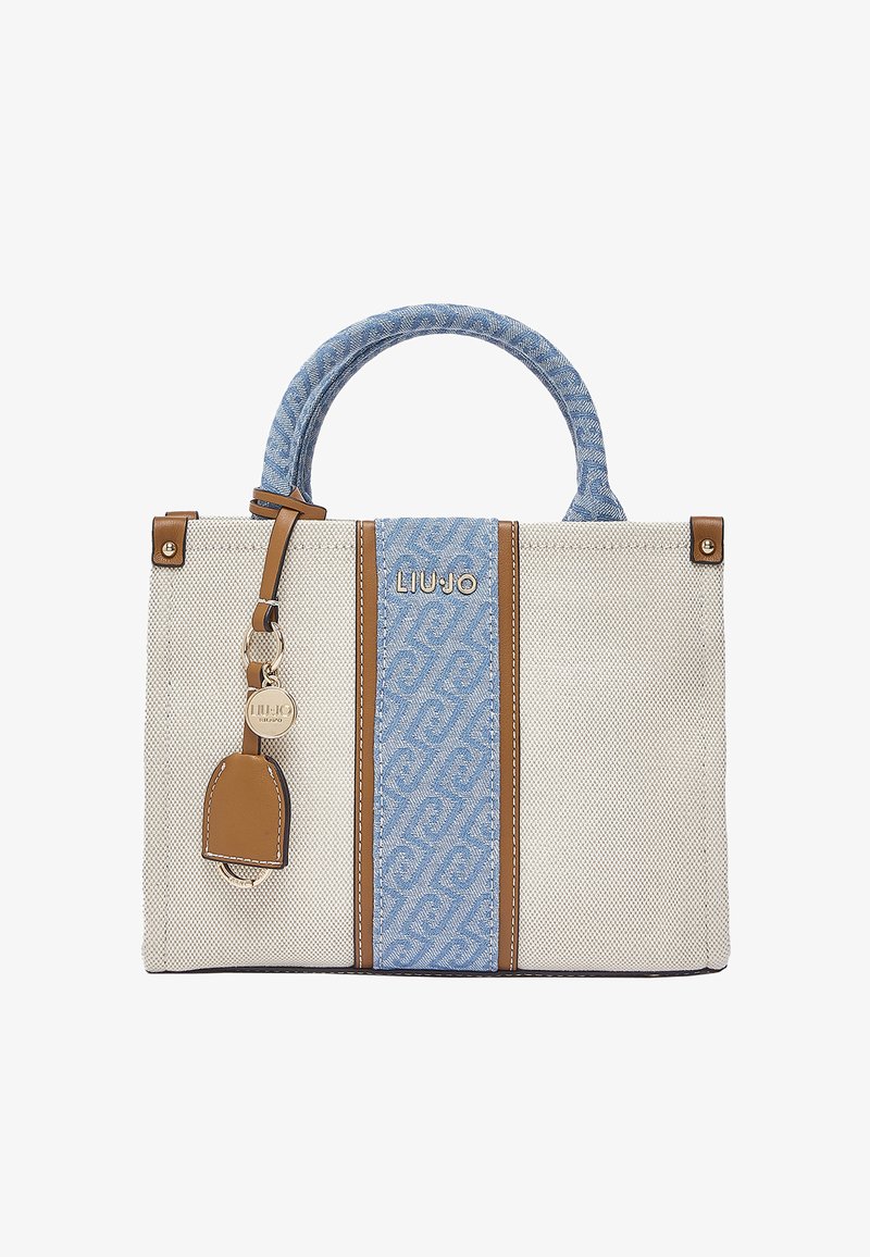 Bolso de tela beige con panel central y asa de patrón azul, detalles en cuero marrón y un charm redondo de marca en tono dorado.