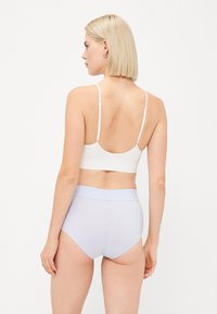 Bela braletka in svetlo modri visokoišči briefs. Mehka tkanina, brezšivna zasnova, nastavljivi naramnice in širok pas.