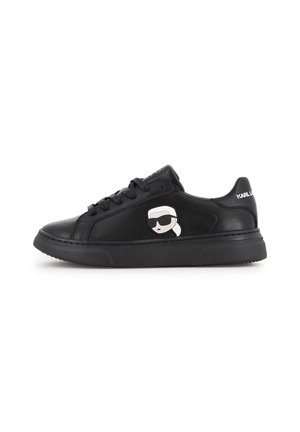 Baskets en cuir noir avec des lacets noirs, un logo visage de dessin animé sur le côté et un texte blanc "Karl Lagerfeld" sur le talon.