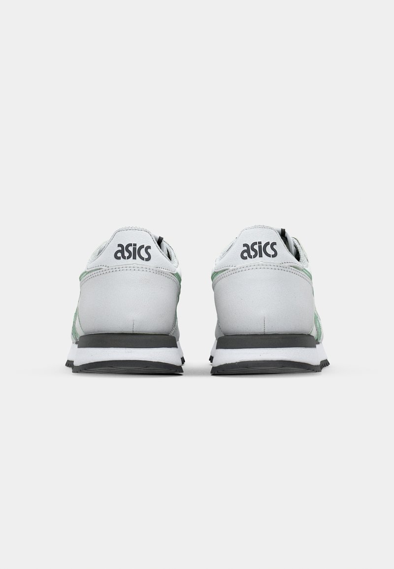 Sneaker grigie e bianche con accenti verdi. Presentano una tomaia texturizzata, un collare imbottito e una suola in gomma nera. Marchio ASICS sul tallone.
