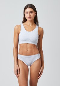 Lichtgrijze katoenen bralette en bijpassende bikini slipjes, met ribbelafwerking en een soepele textuur. De band toont subtiel de merknaam.