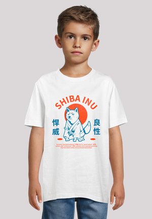 White cotton t-shirt featuring a blue graphic of a Shiba Inu with a red circle background and orange text reading "SHIBA INU." Casual fit.