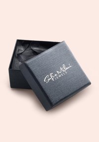 Scatola di gioielli nera con texture, leggermente aperta, interna foderata in carta nera, con la scritta "Sofia Milani Jewels" in bianco.