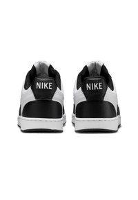 Sneakers Nike con un tallone in pelle nera e parte superiore bianca. Le caratteristiche includono un motivo testurizzato e un marchio "Nike" ben visibile sul tallone.