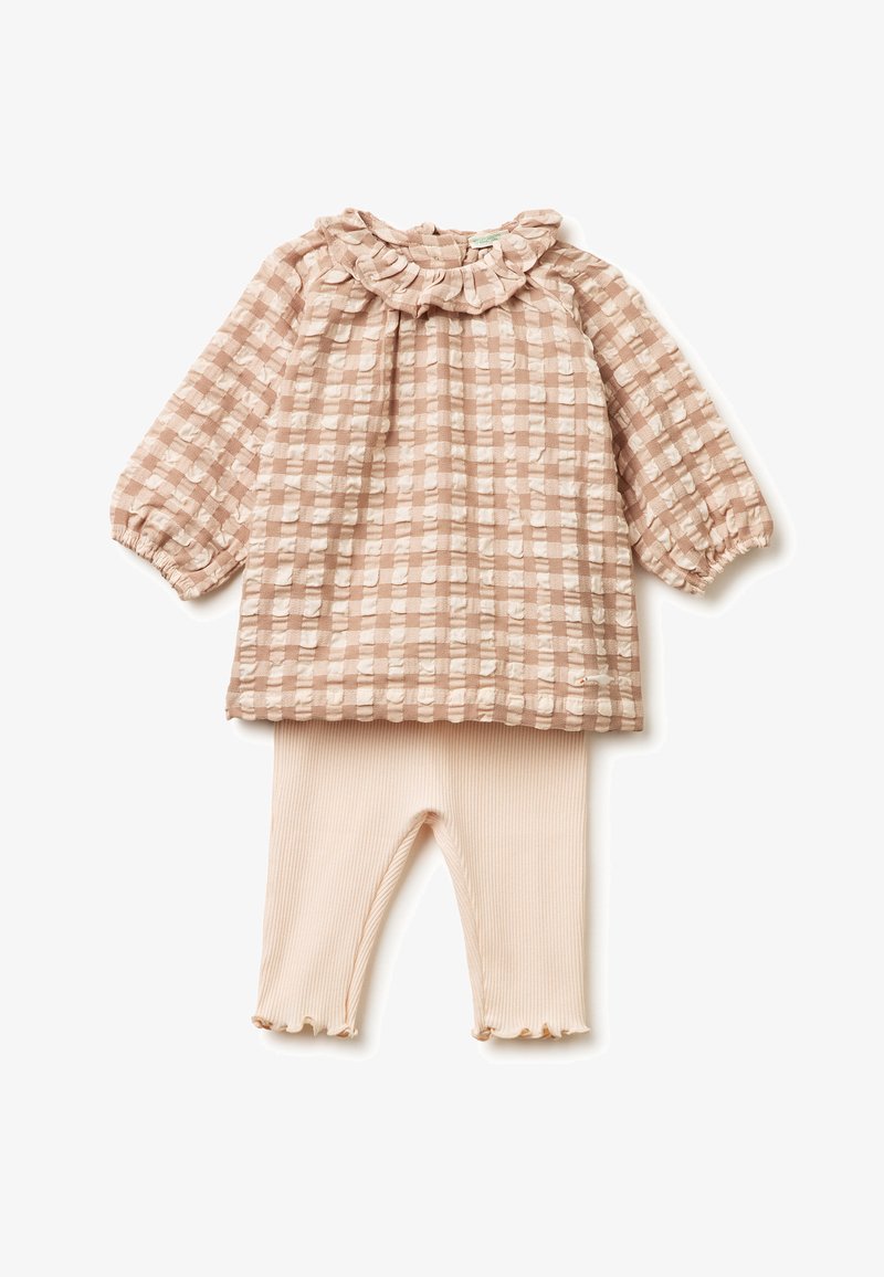 Baby outfit with textured beige checkered long-sleeve top featuring ruffled collar, paired with ribbed light beige leggings with frilled hems.