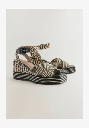Kaldkonnadega sandaalid musta ja beeži kudumisega mustriga, millel on pahkluu rihm, tekstureeritud tald ja dekoratiivne valge helmestus ääres.